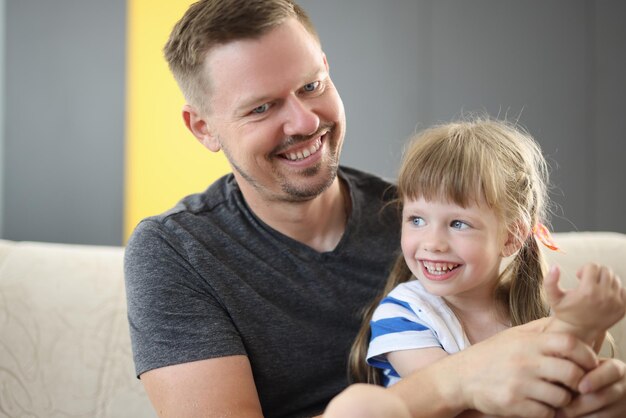 Gelukkige vader die een schattige, vrolijke dochter vasthoudt die lacht en plezier heeft samen