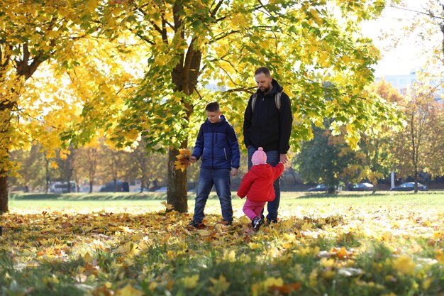 Gelukkige vader die met zijn kinderen buiten in het park speelt