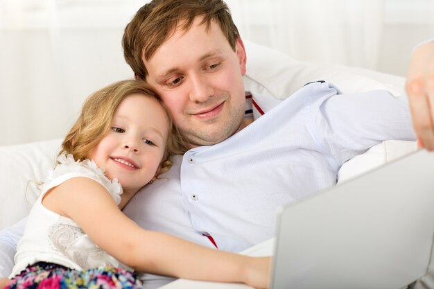 Gelukkige vader en dochter met laptop