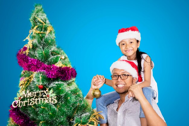 Gelukkige vader en zijn dochter bij een kerstboom