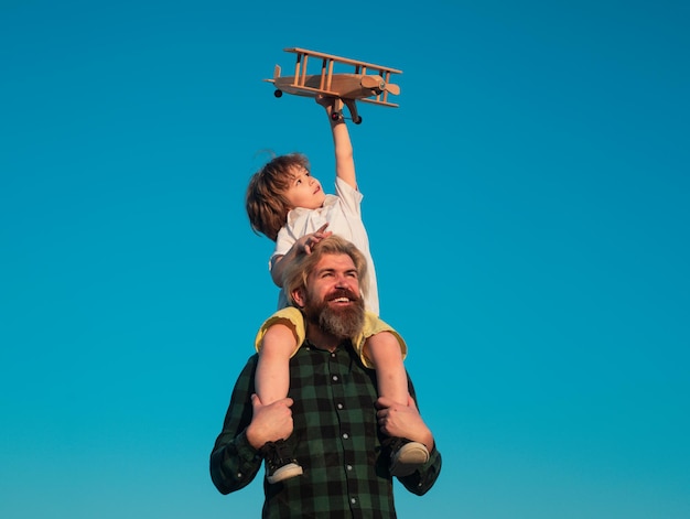 Gelukkige vader en zoon met vliegtuig dromen van reizende papa en kindjongen