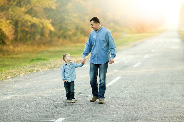 Gelukkige vader en zoon wandelen in de natuur
