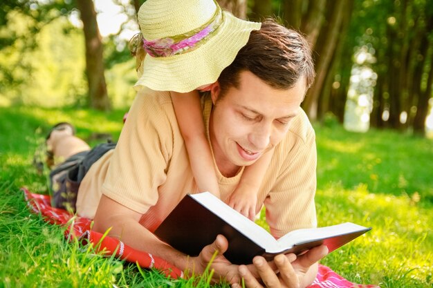 Gelukkige vader met een kind dat een boek leest over de aard van de Bijbel