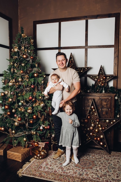 Gelukkige vader met zijn kinderen bij Kerstmis.