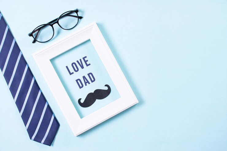 Gelukkige vaderdag. Bovenaanzicht van stropdas, snor, bril en witte fotolijst met LOVE DAD-tekst.