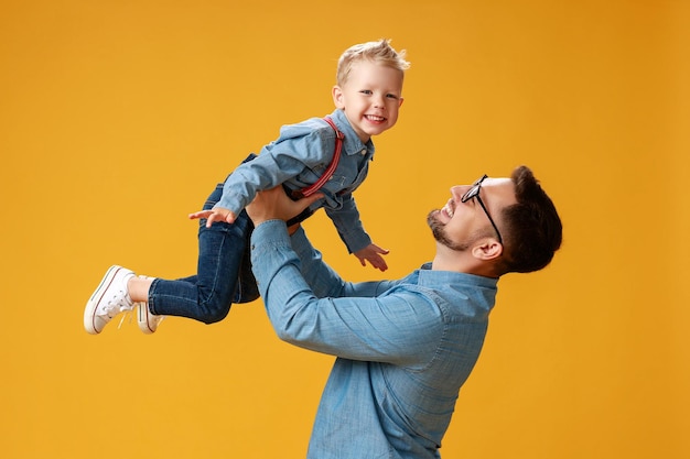 Gelukkige vaderdag schattige vader en zoon knuffelen op gele achtergrond