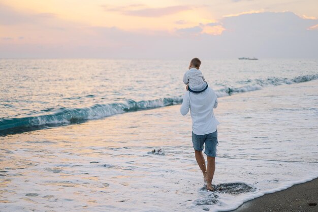 Gelukkige Vaderdag Vader en baby spelen op het strand Papa en hem Kind samen genieten van zonsondergang Liefdevolle alleenstaande vader knuffelt schattig zoontje