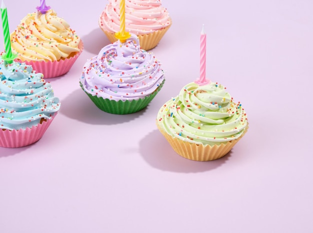 Gelukkige verjaardag concept Cupcakes met room en gekleurde sprinkles op een paarse achtergrond Kopieer ruimte voor tekst