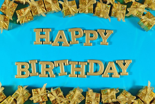 Gelukkige verjaardag gouden tekst en gouden geschenken op een blauwe achtergrond