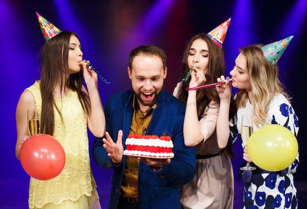 Gelukkige verjaardag! Groep glimlachende vrienden die samen met cake worden verzameld.