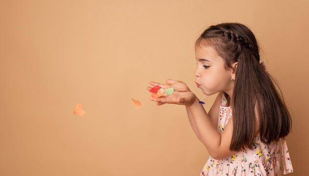 Gelukkige verjaardag kind meisje met confetti op beige achtergrond