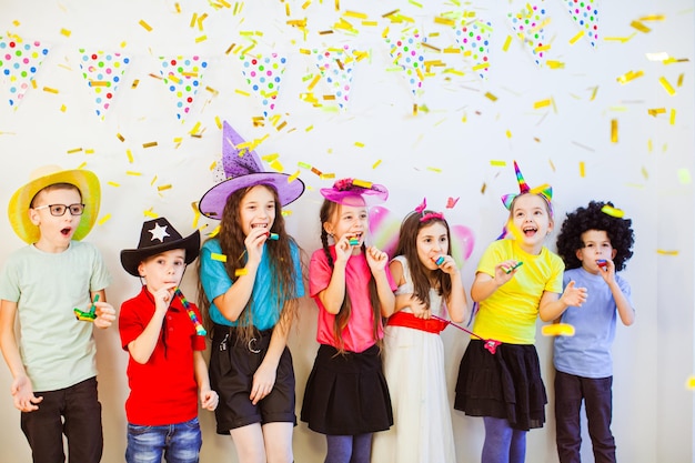 Gelukkige verjaardag kinderen meisjes en jongens met confetti op witte achtergrond Opgewonden emotionele kinderen samen plezier op een feestje