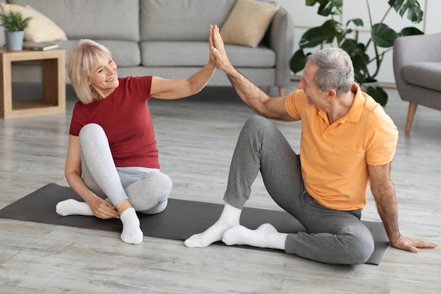 Gelukkige volwassen man en vrouw die training hebben en high five geven