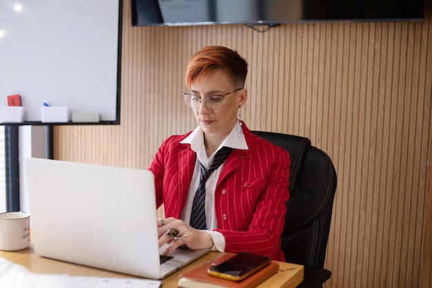 Gelukkige volwassen zakenvrouw ondernemer op kantoor met laptop op het werk