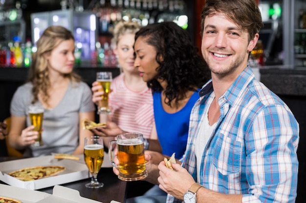 Gelukkige vrienden die een drank en een pizza hebben