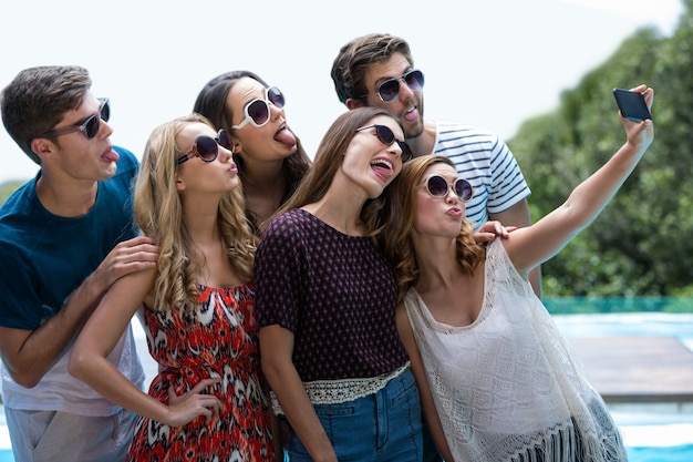 Gelukkige vrienden die een selfie nemen dichtbij zwembad