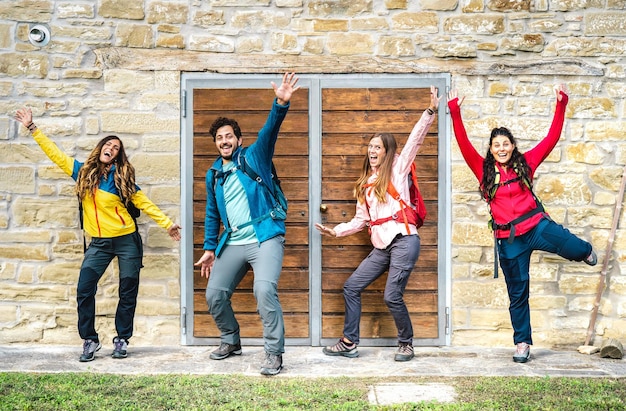 Gelukkige vrienden die plezier hebben in een trekkinghuisje op het platteland poseren voor groepsfoto