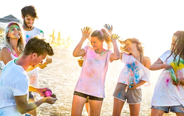 Gelukkige vrienden die plezier hebben op het strandfeest in het zomerfestival van holikleuren