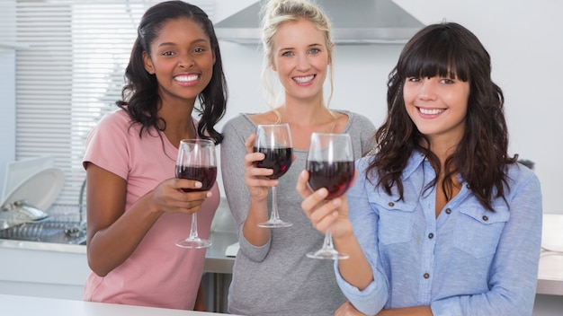 Gelukkige vrienden die van glazen rode wijn genieten