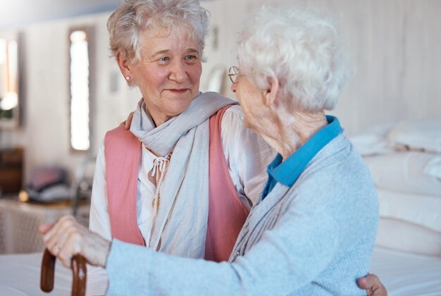 Gelukkige vrienden en oudere vrouwen praten en hechten zich samen in een slaapkamer van een bejaardentehuis Geluksgesprek en gepensioneerde oudere vrouwelijke beste vrienden met een glimlach sprekend over roddels in de kamer