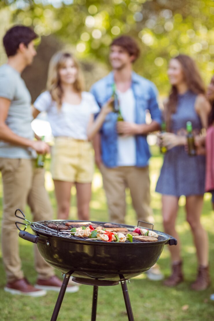 Foto gelukkige vrienden in het park die barbecue hebben