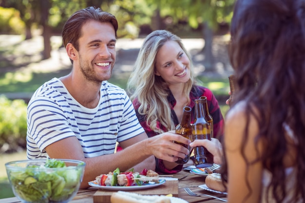 Gelukkige vrienden in het park die lunch hebben