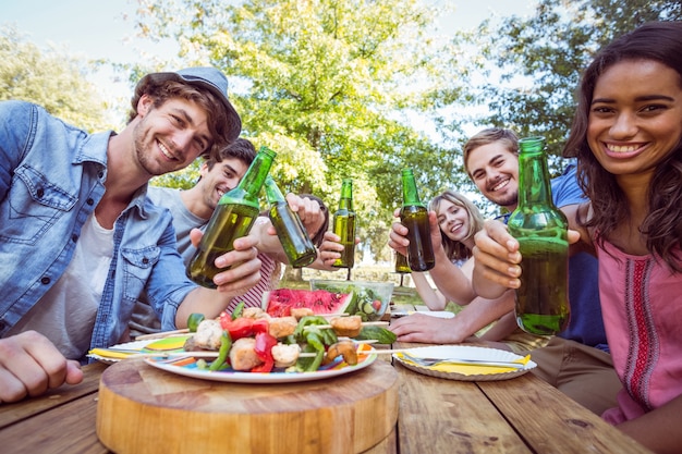 Foto gelukkige vrienden in het park die picknick hebben