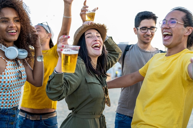 Gelukkige vrienden juichen en cocktails drinken op strandfeest buiten jongeren die plezier hebben in het weekend op vakantie jeugdlevensstijl en reisbestemmingen concept