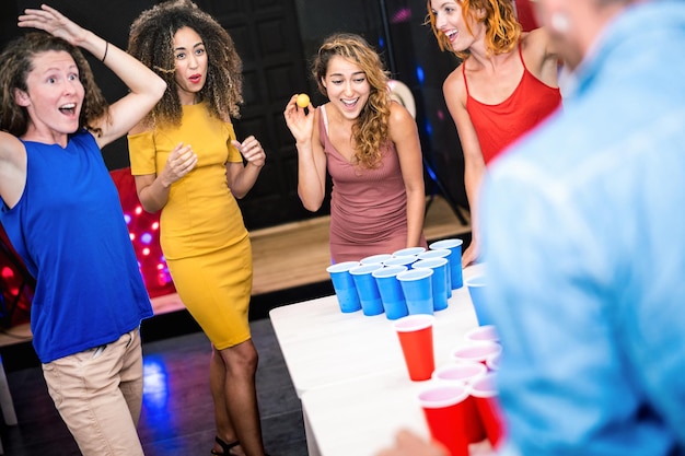 Gelukkige vriendengroep die bierpong speelt in jeugdherberg