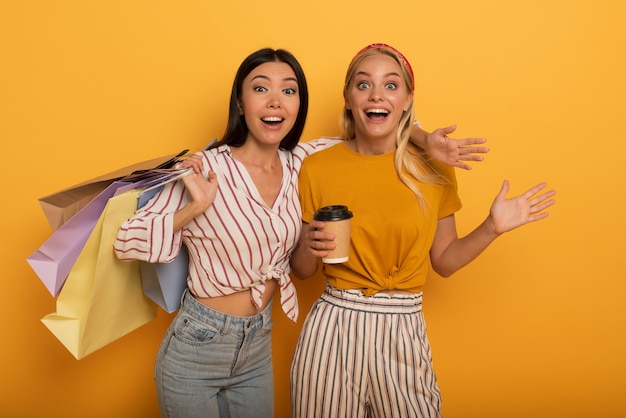 Gelukkige vriendinnen zijn verbaasd over de verkoop van een winkel. verbaasde en emotionele uitdrukking