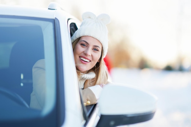 Gelukkige vrouw auto rijden in de besneeuwde winter. hoge kwaliteit foto