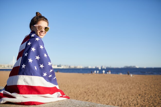 Gelukkige vrouw bedekt met grote Amerikaanse vlag