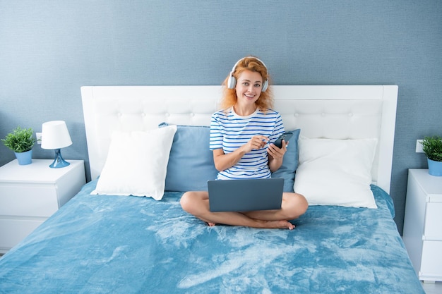 Gelukkige vrouw chatten op telefoon vrouw met telefoon chat thuis telefoon chat van vrouw in hoofdtelefoons