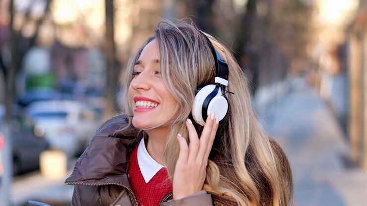 Foto gelukkige vrouw die aan muziek op draadloze hoofdtelefoons luistert