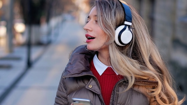 Gelukkige vrouw die aan muziek op draadloze hoofdtelefoons luistert
