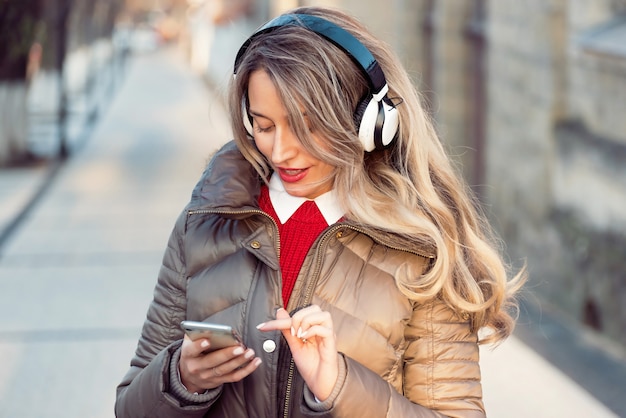 Gelukkige vrouw die aan muziek op draadloze hoofdtelefoons luistert