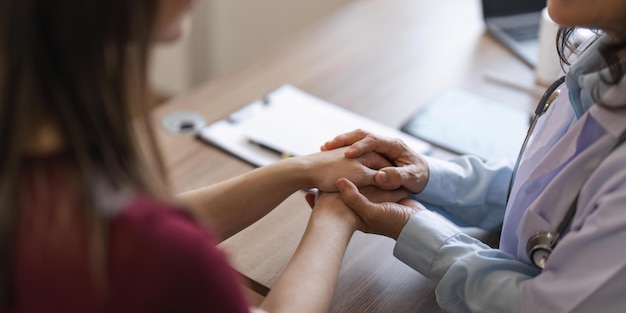 Foto gelukkige vrouw die arts senior bezoekt die optimistisch nieuws krijgt na medische controletherapie