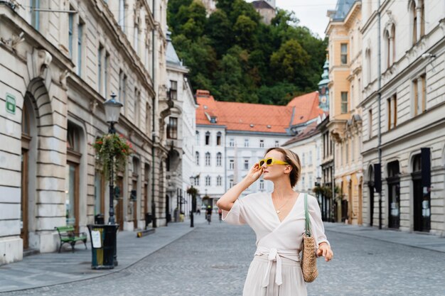 Gelukkige vrouw die Europese bezienswaardigheden verkent Drie bruggen in Ljubljana Slovenië Reizen door Europa