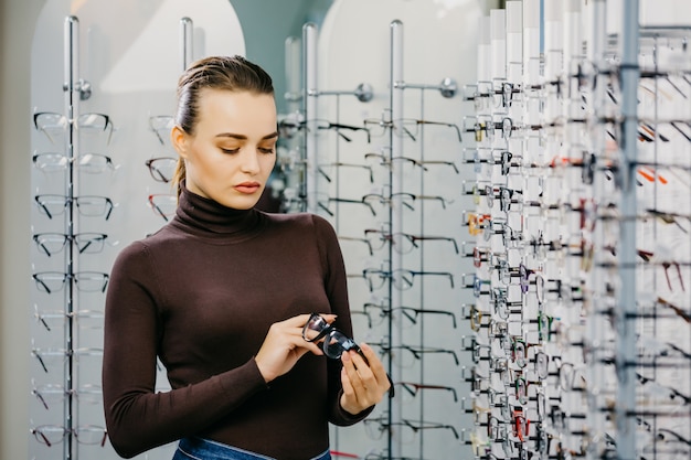 Gelukkige vrouw die glazen kiezen bij optische opslag.