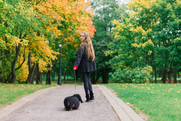 Gelukkige vrouw die haar kleine hond in de armen houdt