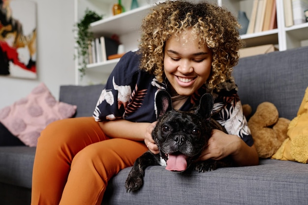 Gelukkige vrouw die haar schattige hond streelt