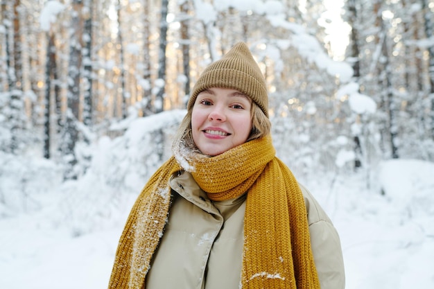 Gelukkige vrouw die in de winterbos loopt