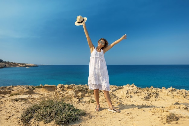 Gelukkige vrouw die lacht op het strand genieten van zomervakantie