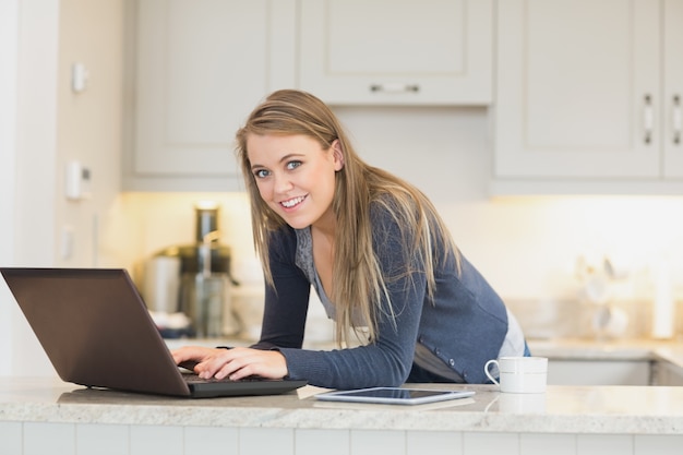 Gelukkige vrouw die laptop met behulp van