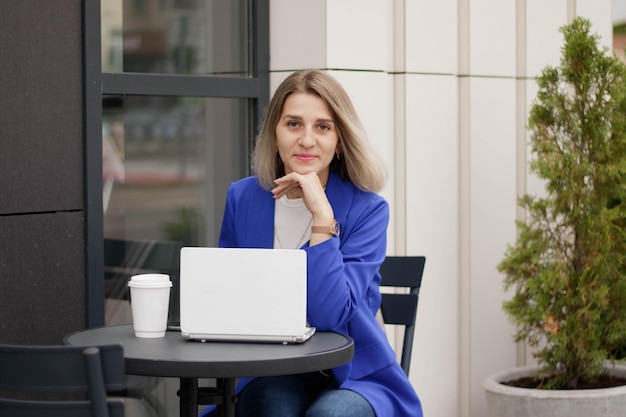 Gelukkige vrouw die online media-inhoud bekijkt op laptop die in een park zit
