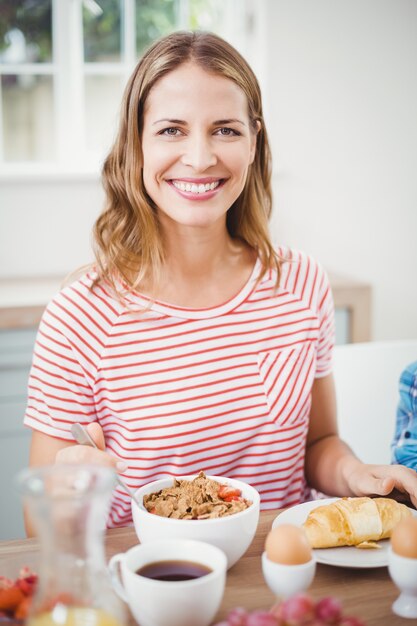 Gelukkige vrouw die ontbijt doet aan lijst