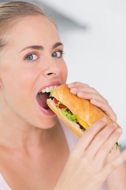 Gelukkige vrouw die sandwich eet