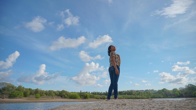 Gelukkige vrouw die van schoonheidsstrand geniet