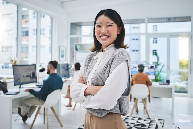 Gelukkige vrouw en Aziatische werknemer met gekruiste armen op kantoorwerkplek en vertrouwen in het werken voor professionele startup Portretglimlach en persoon met trots en geluk in het bedrijfsleven in Singapore
