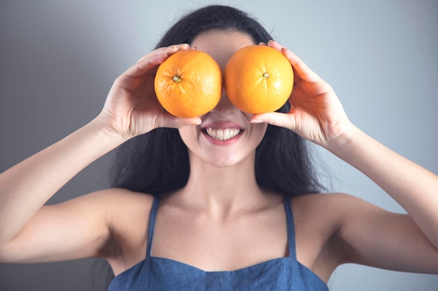 Gelukkige vrouw hand oranje in oog